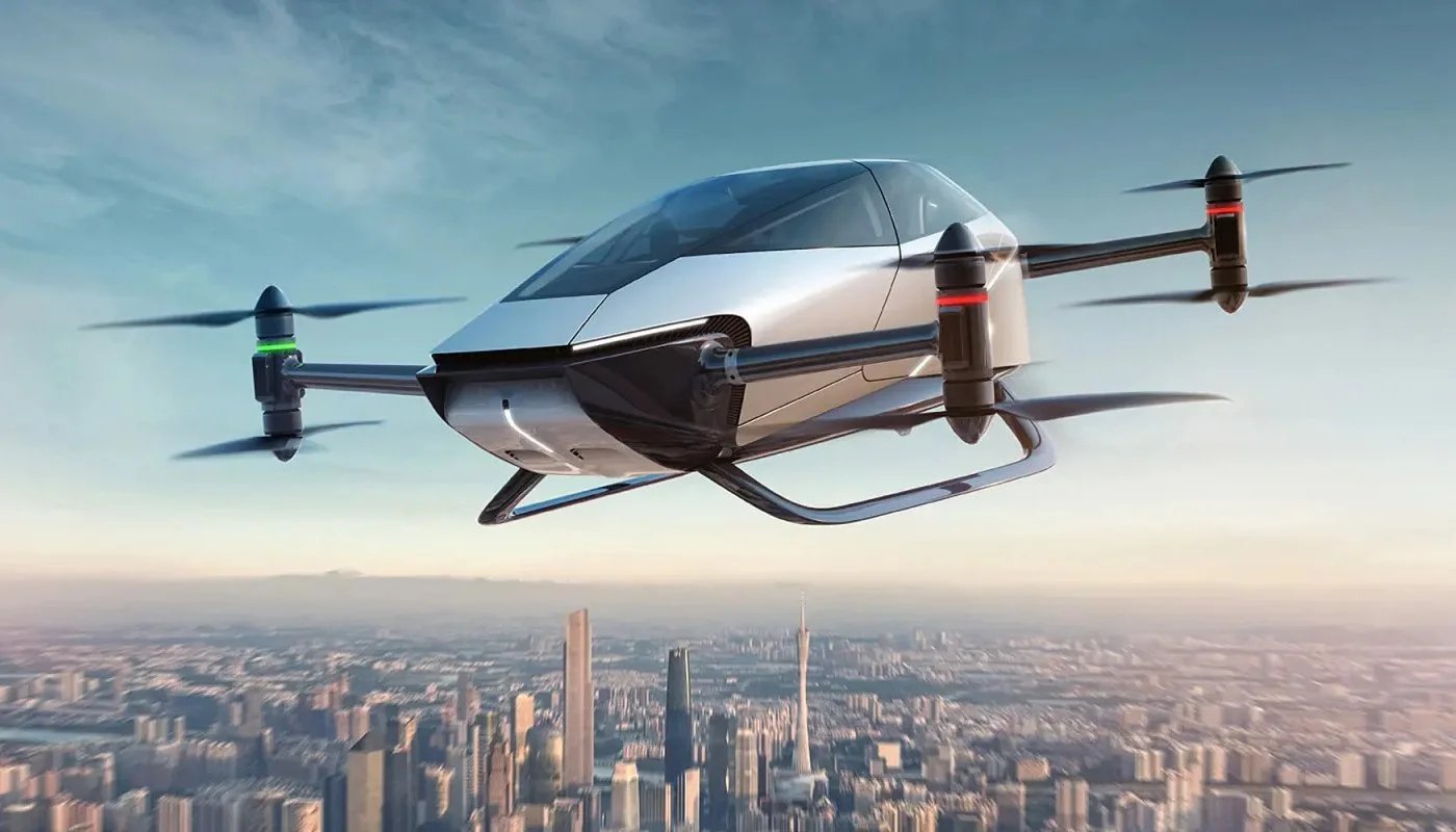Un vehículo aéreo similar a un dron, sobrevolando una ciudad con rascacielos al fondo.